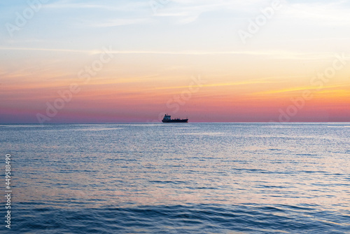 barco no horizonte com por do sol no mar © Janjiulio