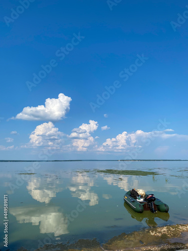 Complete calm water on the Volga river and clear reflections of clouds in the water on a hot July day.