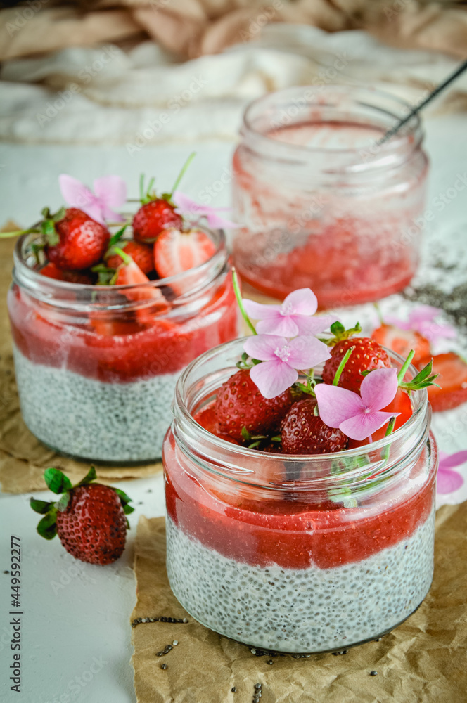 Healthy strawberry fruit dessert with milk and chia seeds in jar on light background. Healthy raw vegetarian dessert. Healthy strawberry fruit dessert with milk and chia seeds in jar on light background. Healthy raw vegetarian dessert.
