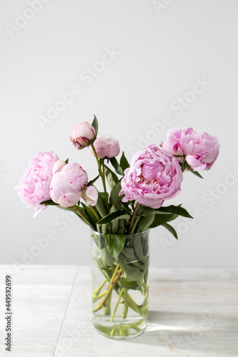 Bridal bouquet of pink peonies in a glass vase on a wooden table