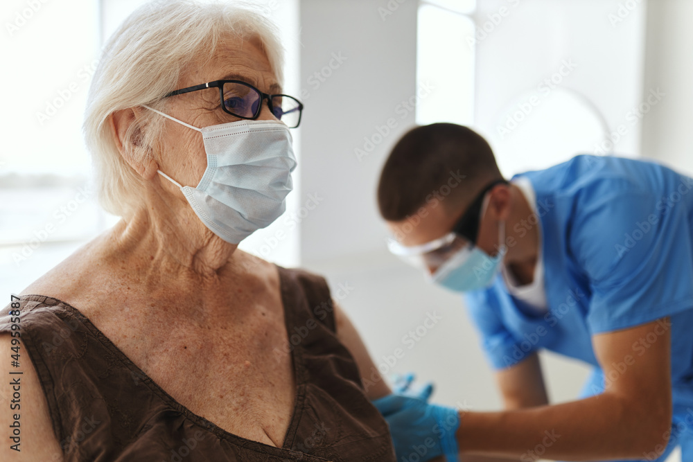 doctor giving an injection to an elderly woman patient covid passport doctor giving an injection to an elderly woman patient covid passport