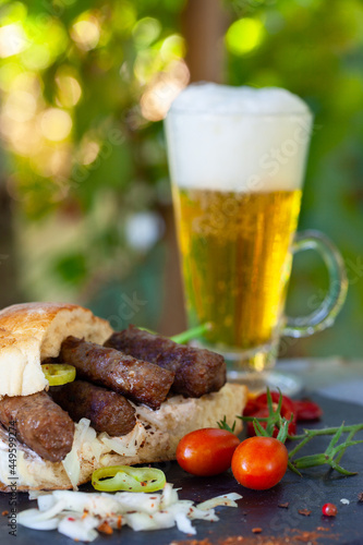 Cevapi, cevapcici, Balkan minced meat kebab served with onion, hot peppers and beer.