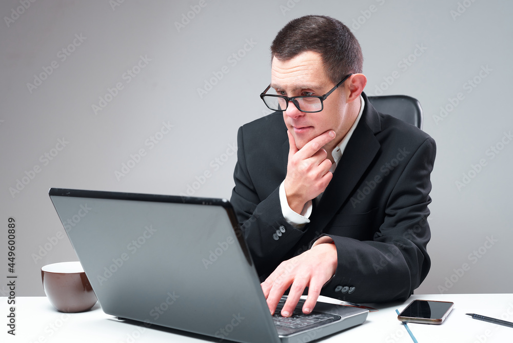 Social inclusion: Down syndrome businessman working on his laptop in his office Social inclusion: Down syndrome businessman working on his laptop in his office