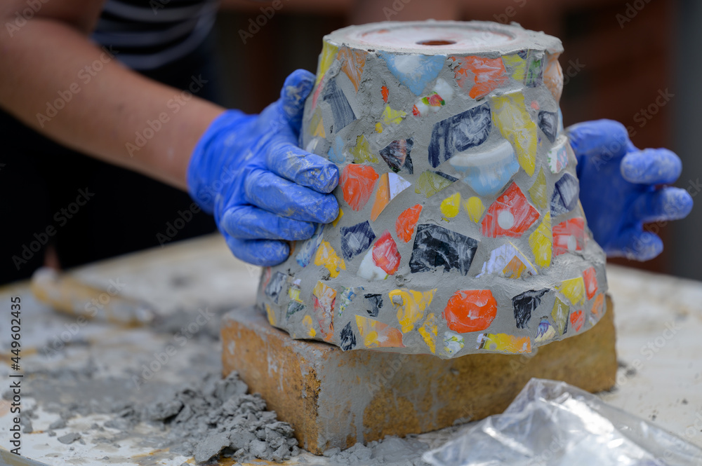 Older people decorate earthenware with mosaic techniques in the master class or in the fresh air in the workshop. Homemade mosaic flower pot with porcelain pieces. Older people decorate earthenware with mosaic techniques in the master class or in the fresh air in the workshop. Homemade mosaic flower pot with porcelain pieces.