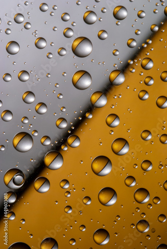 Abstract split background with water drops on the glass. Gold and silver. The concept of a natural cosmetic product.