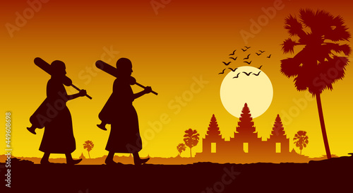 monk walk out of temple pilgrimage to make merit across angkor wat of cambodia. for peace silent and dharma in sunset scene silhouette style photo
