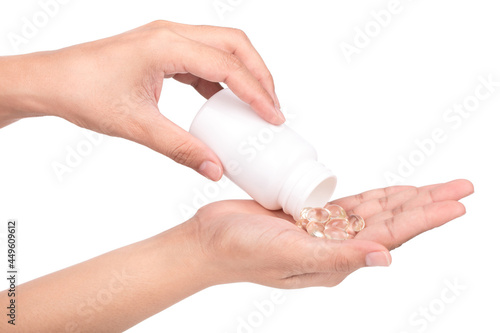 Close up of oil filled capsule or soft gel on hand isolated on white background.