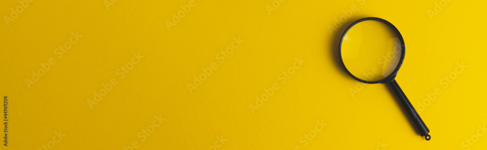 Black magnifying glass on a yellow background. Search concept. Baner format. Copy space text. Black magnifying glass on a yellow background. Search concept. Baner format. Copy space text.