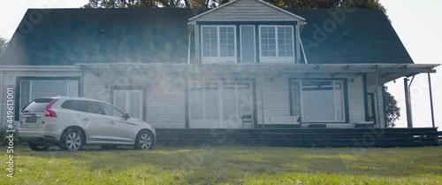 TRACKING Happy Caucasian family of four arriving by car to an American countryside house. Shot with 2x anamorphic lens