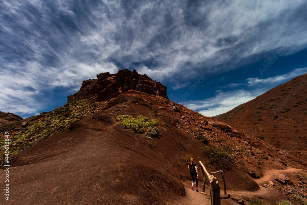 Woman hikes on a hill of Quebrada de las Conchas in Salta, Argentina Woman hikes on a hill of Quebrada de las Conchas in Salta, Argentina
