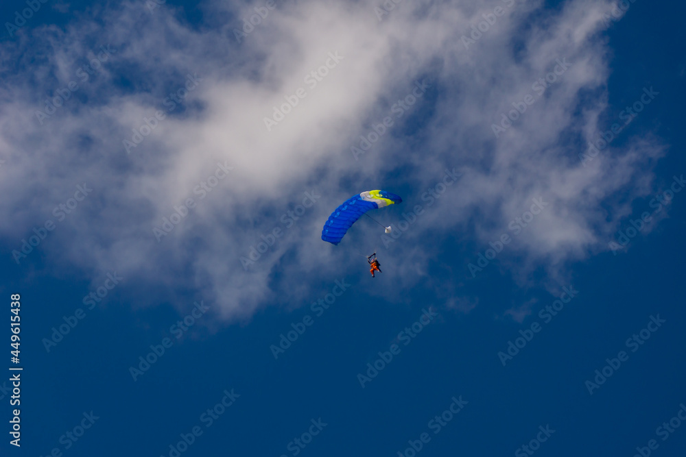 blue paraglider soars against the blue sky blue paraglider soars against the blue sky
