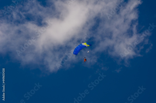 blue paraglider soars against the blue sky
