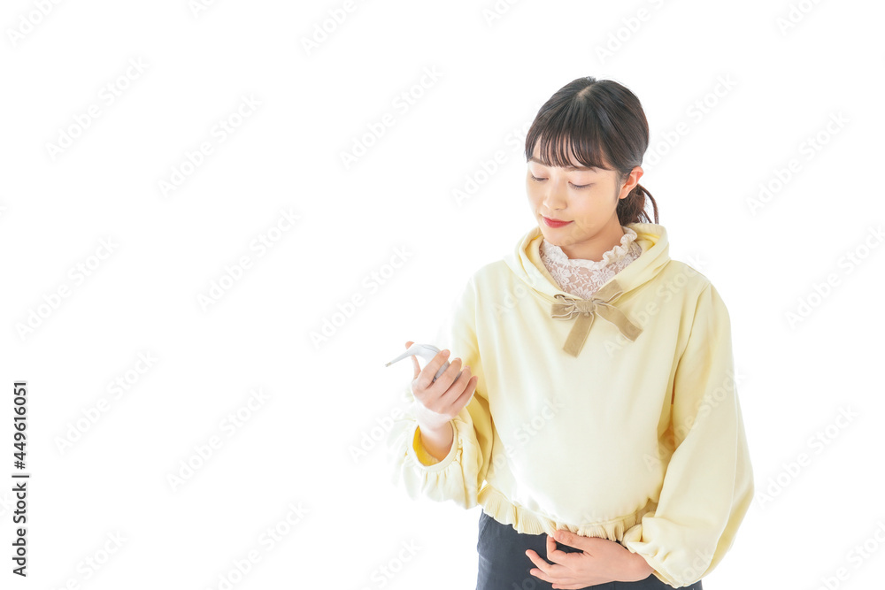 検温をする若い妊婦の女性 検温をする若い妊婦の女性