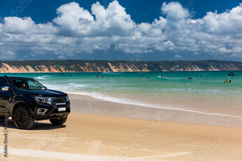 4WD vehicles and surfers at Double Island Point on a sunny day photo