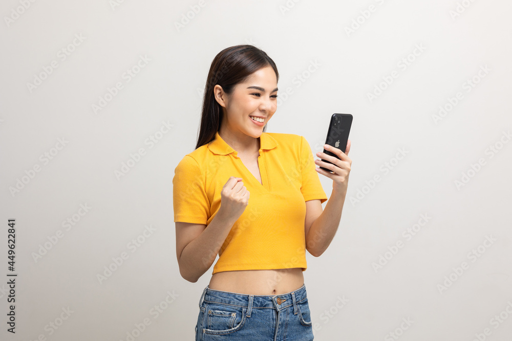 Pretty young asian woman using smartphone standing on isolated white background. She texting on cell phone. Pretty young asian woman using smartphone standing on isolated white background. She texting on cell phone.