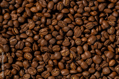 Roasted coffee beans closeup Background, Coffee grains scattered on the table, working hours coffee, hot drinks.