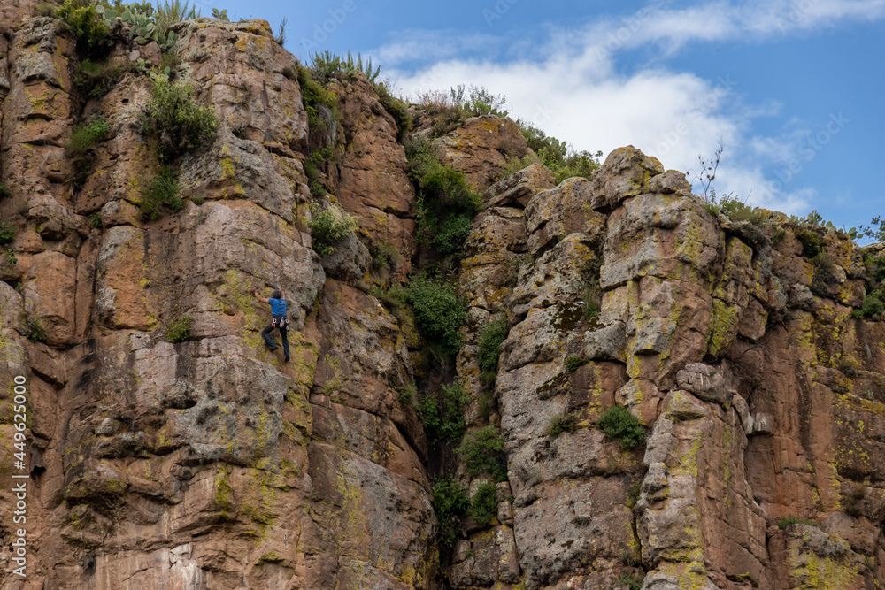 hombre fuerte escalando montaña en la cima