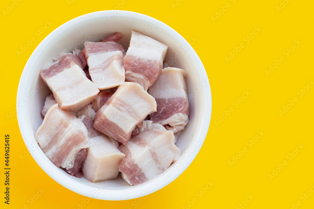 Streaky pork in white bowl on yellow background. Streaky pork in white bowl on yellow background.