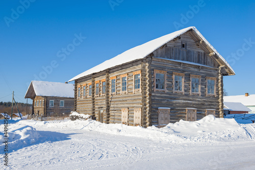 Ancient wooden houses of the Arkhangelsk province on a sunny winter day. Oshevenskaya volost, Arkhangelsk region