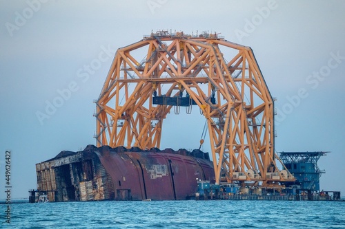 Capsized cargo ship being disassembled
