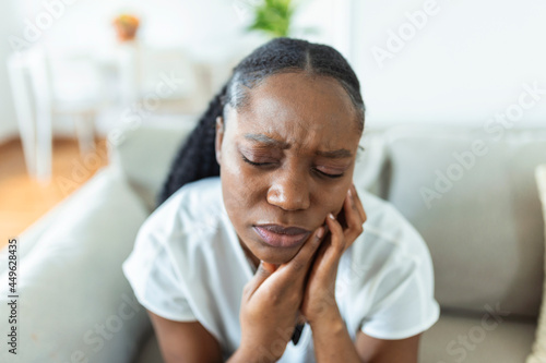 Portrait of unhappy African-American woman suffering from toothache at home. Healthcare, dental health and problem concept. Stock photo © Graphicroyalty