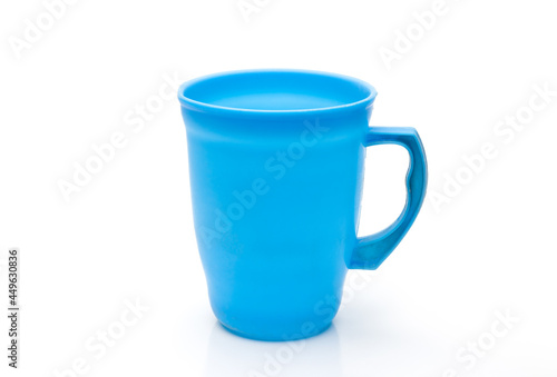 Blue color plastic glass or jug close up on isolated white background with reflection