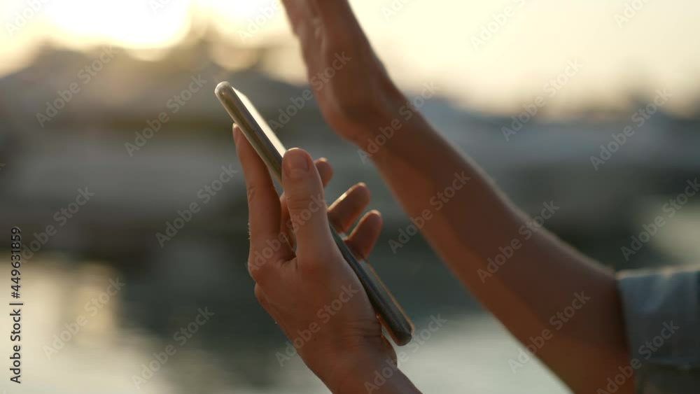 close-up of a woman hands viewing a message by flipping her fingers on the touch screen of the phone close-up of a woman hands viewing a message by flipping her fingers on the touch screen of the phone
