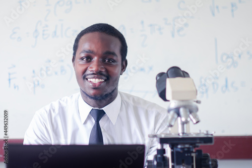 Fotografie African scientist teacher is teaching science classes with using microscope in the classroom