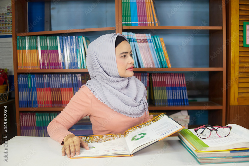 islamic woman turn around and reading book on table islamic woman turn around and reading book on table