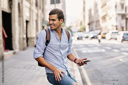 young handsome man smiling with smartphone at via laietana in Barcelona photo