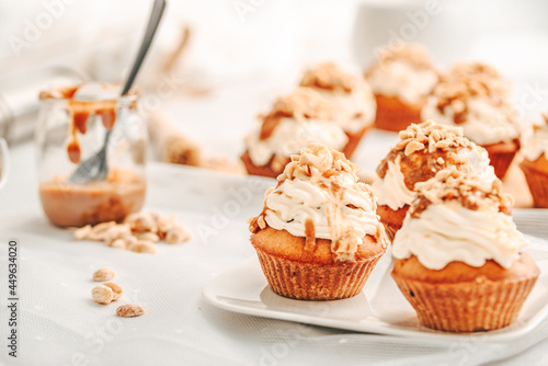 Muffin. Creme muffins with caramel and nuts. Creme on the top of muffin. Caramel muffins.  