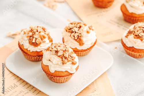 Muffin. Creme muffins with caramel and nuts. Creme on the top of muffin. Caramel muffins.  