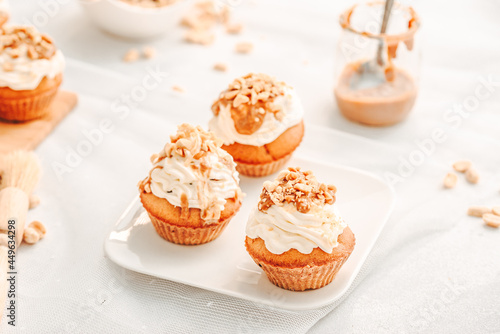 Muffin. Creme muffins with caramel and nuts. Creme on the top of muffin. Caramel muffins. 