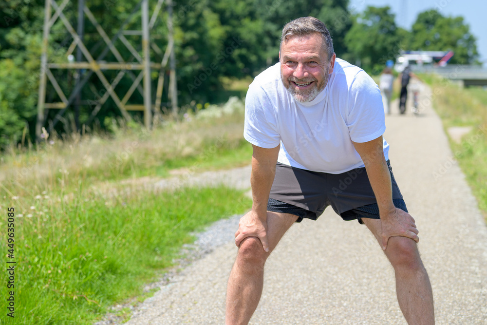 Happy healthy man taking a rest while out jogging Happy healthy man taking a rest while out jogging