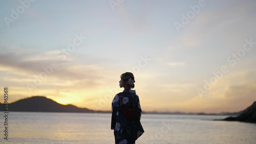 夕暮れの海にいる浴衣の女性