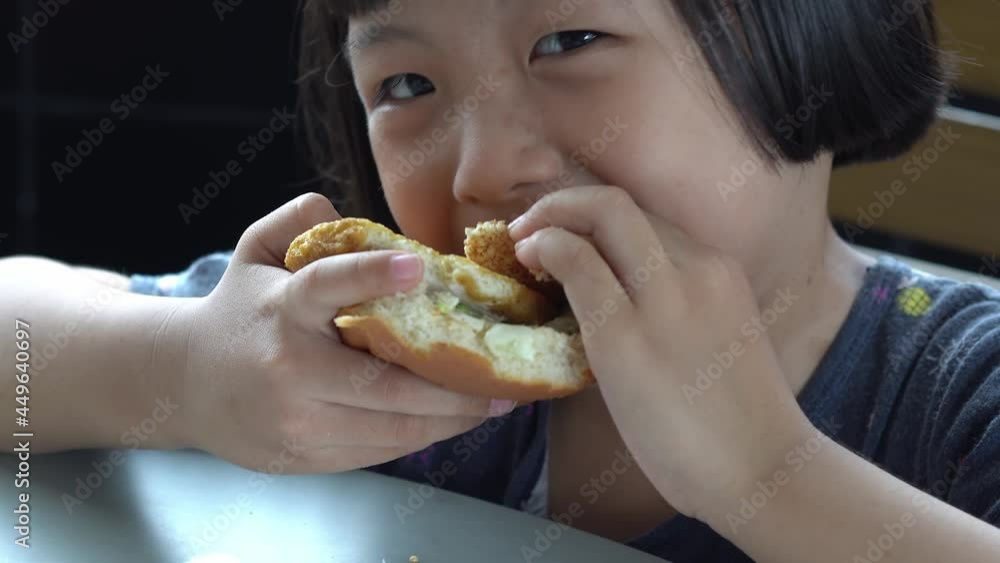 Smiling chines kid eat delicious hamburger. Junk food, fast food concept Smiling chines kid eat delicious hamburger. Junk food, fast food concept