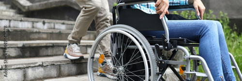 Man tries to drag wheelchair with woman onto stairs