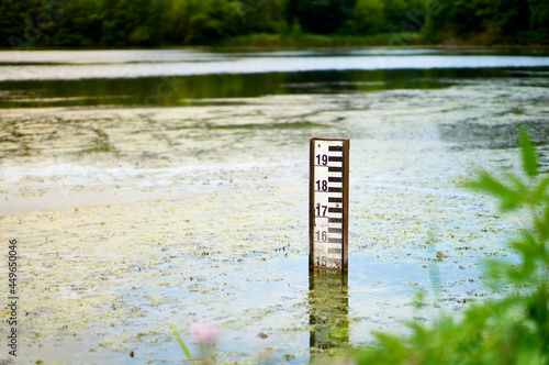 Lake water level sign in Falenty, Poland. Water level depth meter in the pond photo