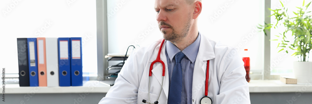Male doctor working on laptop in medical office Male doctor working on laptop in medical office