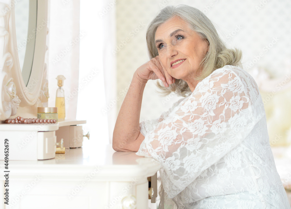 portrait of happy senior woman sitting near dressing table