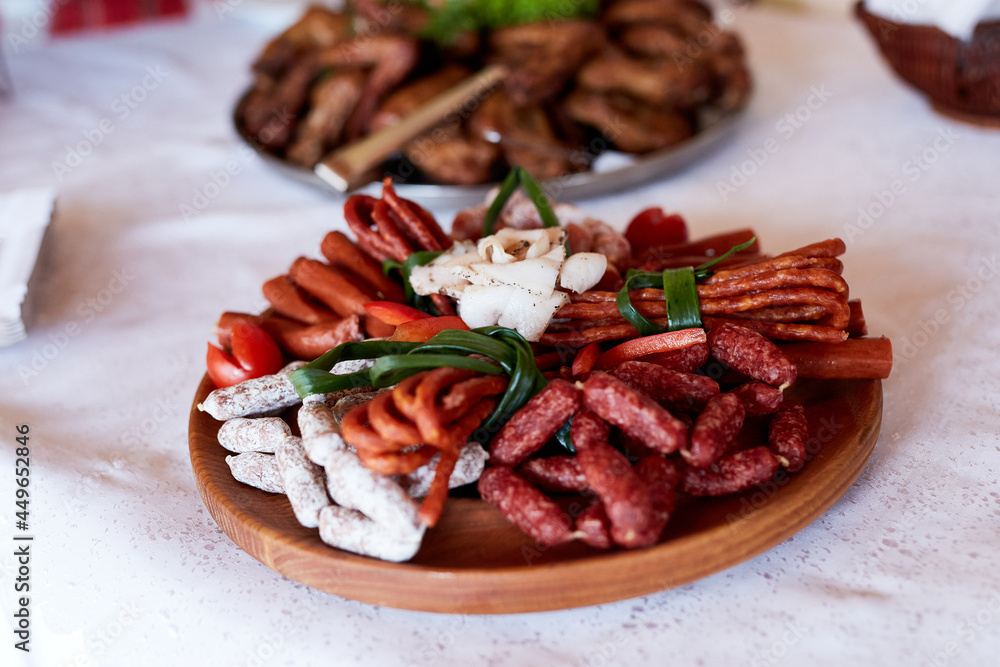 Snacks at the wedding, cheese, sausage, vegetables, meat products, Cossack table at the Ukrainian wedding.