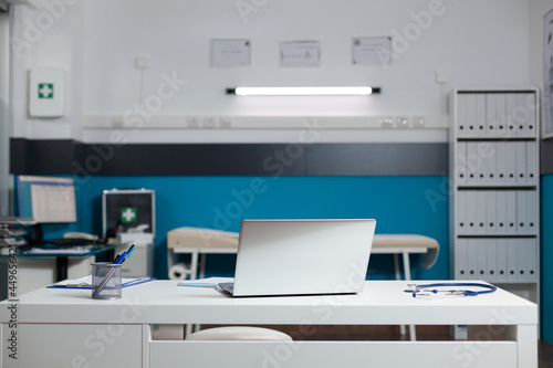 Empty doctors office room with medical equipment used for appointments with patients at clinic. Nobody in healthcare cabinet indoors, deisgned for professional consultation and medic