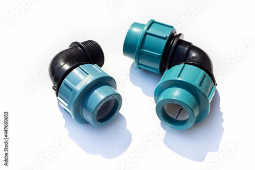 Black coupling for connecting plastic pipes on a white background. Residential water supply system components.