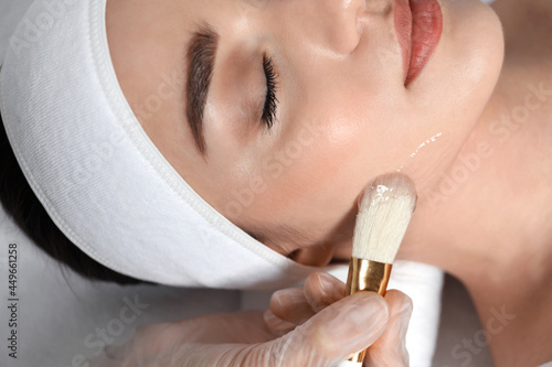 Photos Young woman during face peeling procedure in salon, closeup