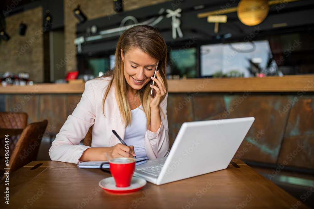 Young woman enjoying a cup of coffee. Portrait of a young beautiful businesswomen enjoying coffee during work on portable laptop computer, charming female student using net-book while sitting in cafe Young woman enjoying a cup of coffee. Portrait of a young beautiful businesswomen enjoying coffee during work on portable laptop computer, charming female student using net-book while sitting in cafe