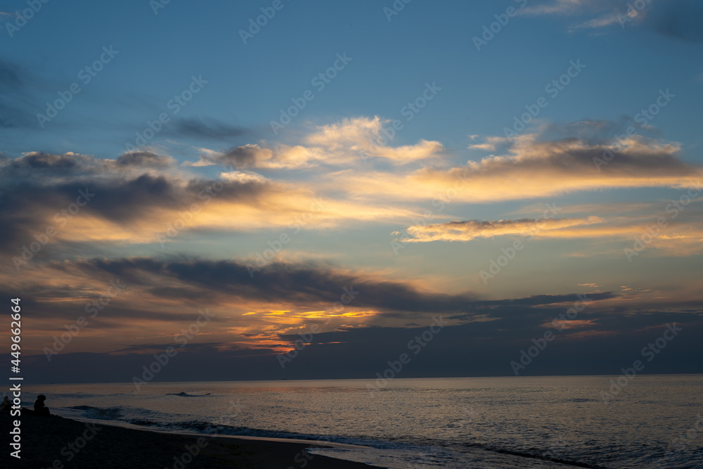 Sunset at the sea. Evening sun and path. Beautiful sky and clouds. Landscape on the coast. Ocean shore. Dawn. Nature. Waves and surf. Relaxation and culm