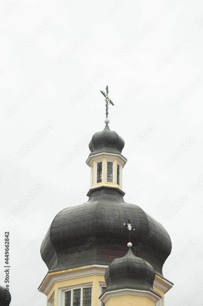 beige church with black domes on a background of white sky