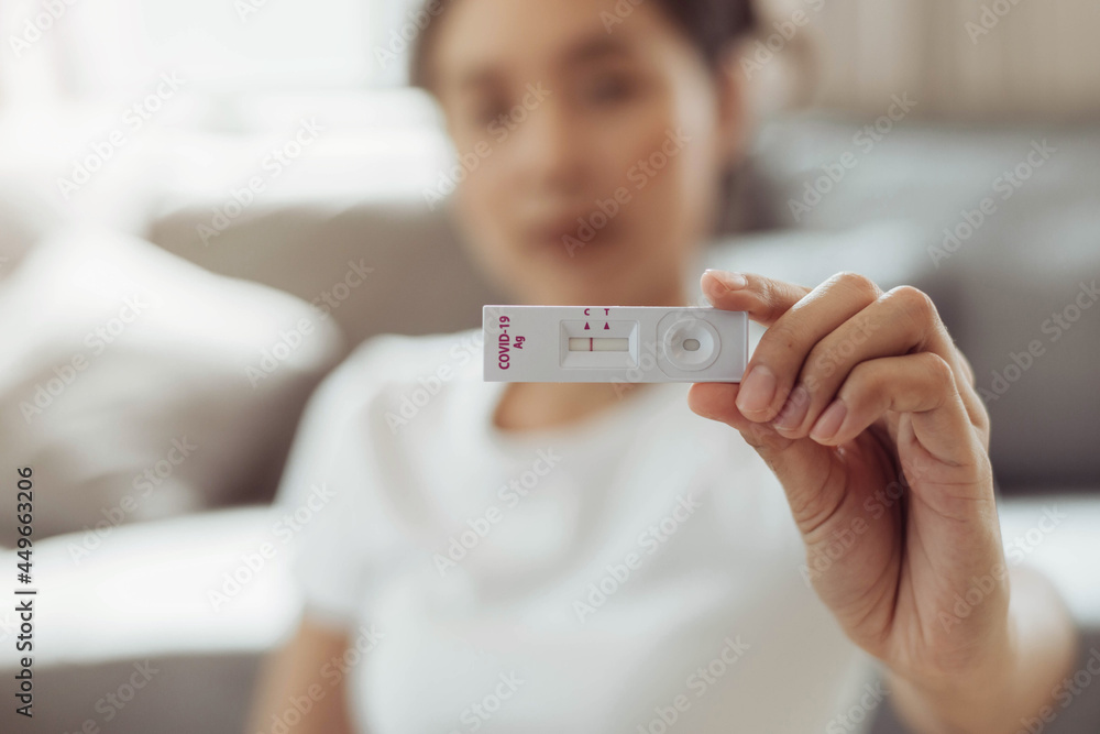 Woman self test for COVID19 home test kit. asian woman showing result
