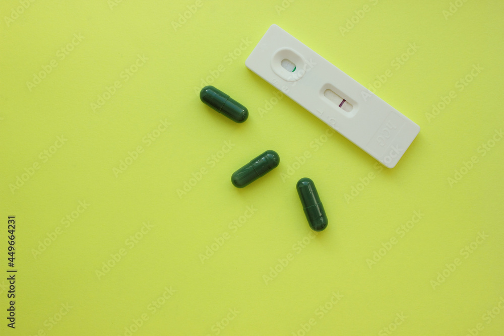 Fototapeta premium Negative pregnancy test and pills on a yellow background. Motherhood, children, pregnancy, concept of birth control. Health problems and problems with conception. abortion. contraception. Copy space.