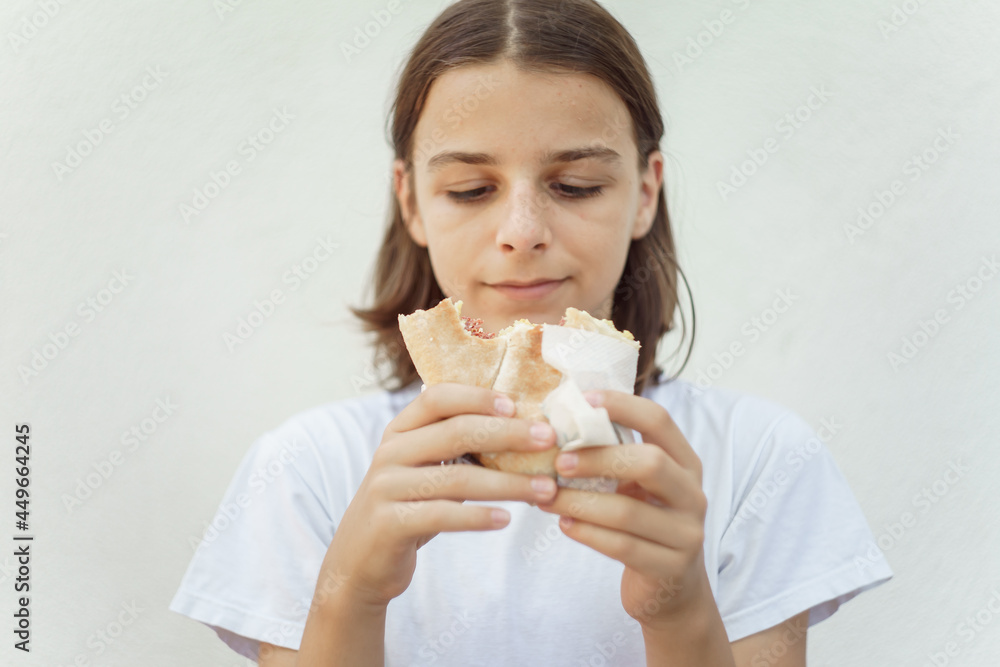 hungry boy eats a sandwich set against a white background. 